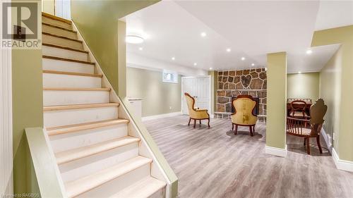 Staircase featuring hardwood / wood-style floors and a stone fireplace - 490 7Th Street W, Owen Sound, ON - Indoor Photo Showing Other Room