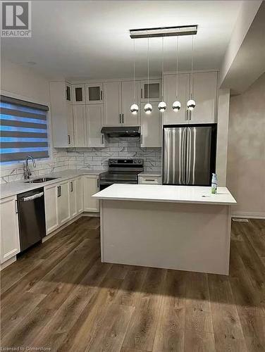 Kitchen with white cabinets, stainless steel appliances, hanging light fixtures, and dark wood-type flooring - 106 Jayla Lane, Smithville, ON - Indoor Photo Showing Kitchen With Upgraded Kitchen