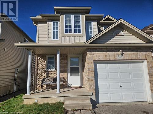 View of front of property featuring a garage and covered porch - 973 Atlantic Boulevard, Waterloo, ON - Outdoor