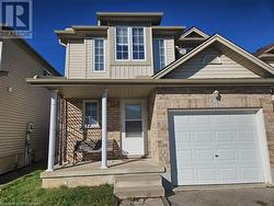 View of front of property featuring a garage and covered porch - 