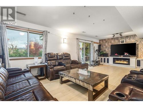 Bottom Floor - Living Room with door leading to Backyard. - 1730 Simpson Court, Kelowna, BC - Indoor Photo Showing Living Room With Fireplace