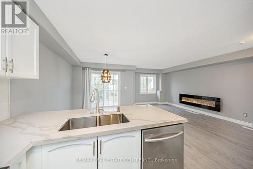 100 - 620 Ferguson Drive, Milton, ON - Indoor Photo Showing Kitchen With Fireplace