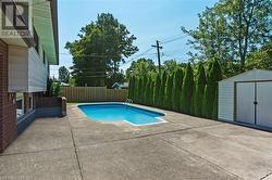 View of swimming pool featuring a storage unit and a patio area - 