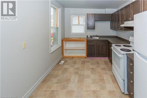 Unit 56 Kitchen featuring dark brown cabinetry, sink, and white appliances - 60 Wellington St N/S Street N, Woodstock, ON - Indoor Photo Showing Kitchen