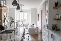 Living room featuring dark hardwood / wood-style floors, ornamental molding, and sink - 