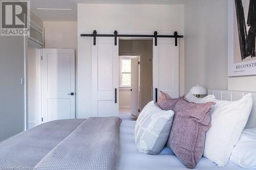 Bedroom featuring a barn door - 109 East Avenue S, Hamilton, ON - Indoor Photo Showing Bedroom