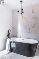 Bathroom featuring a tub and a notable chandelier - 