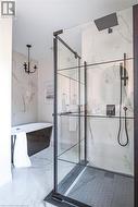 Bathroom featuring a notable chandelier and independent shower and bath - 