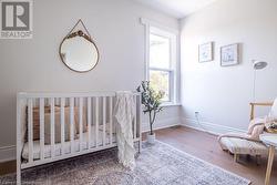 Bedroom with a crib and wood-type flooring - 