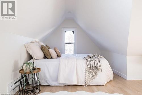 Bedroom with a baseboard radiator, vaulted ceiling, and hardwood / wood-style flooring - 109 East Avenue S, Hamilton, ON - Indoor Photo Showing Bedroom