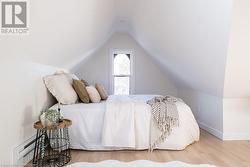 Bedroom with a baseboard radiator, vaulted ceiling, and hardwood / wood-style flooring - 