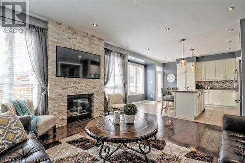 Living room with a fireplace, light wood-type flooring, and sink - 906 Farmstead Drive, Milton, ON - Indoor Photo Showing Living Room With Fireplace