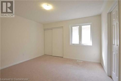 Unfurnished bedroom featuring light carpet and a closet - 906 Farmstead Drive, Milton, ON - Indoor Photo Showing Other Room