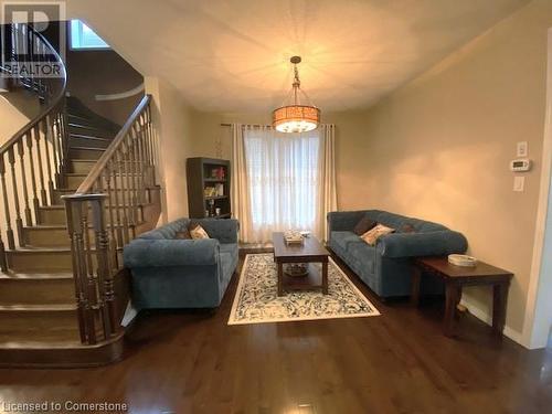 Living room with dark hardwood / wood-style floors and a notable chandelier - 906 Farmstead Drive, Milton, ON - Indoor Photo Showing Living Room