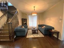 Living room with dark hardwood / wood-style floors and a notable chandelier - 