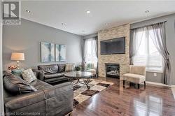 Living room with a fireplace, plenty of natural light, and hardwood / wood-style flooring - 