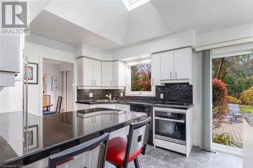 Kitchen with decorative backsplash, white cabinetry, and oven - 103 Mcgregor Crescent, Ancaster, ON - Indoor Photo Showing Kitchen