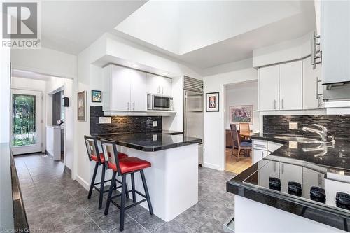 Kitchen featuring built in appliances, sink, white cabinetry, and backsplash - 103 Mcgregor Crescent, Ancaster, ON - Indoor Photo Showing Kitchen With Upgraded Kitchen