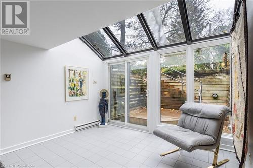 Sunroom with vaulted ceiling with skylight and a baseboard heating unit - 103 Mcgregor Crescent, Ancaster, ON - Indoor Photo Showing Other Room