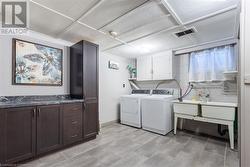 Laundry room featuring cabinets and separate washer and dryer - 