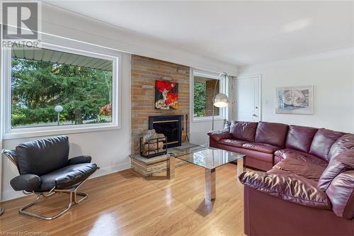 Living room with light hardwood / wood-style floors, a brick fireplace, and plenty of natural light - 103 Mcgregor Crescent, Ancaster, ON - Indoor Photo Showing Living Room With Fireplace