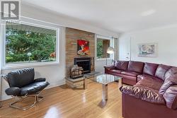 Living room with light hardwood / wood-style floors, a brick fireplace, and plenty of natural light - 