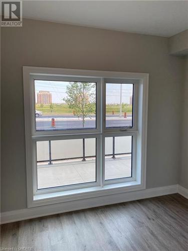 Unfurnished room with wood-type flooring and a wealth of natural light - 128 Grovewood Common Unit# 117, Oakville, ON - Indoor Photo Showing Other Room