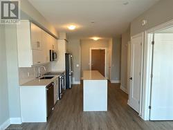 Kitchen featuring white cabinets, appliances with stainless steel finishes, dark hardwood / wood-style floors, and tasteful backsplash - 