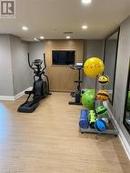 Exercise area with light hardwood / wood-style flooring - 