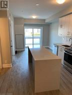 Kitchen featuring sink, a center island, dark hardwood / wood-style flooring, decorative backsplash, and appliances with stainless steel finishes - 