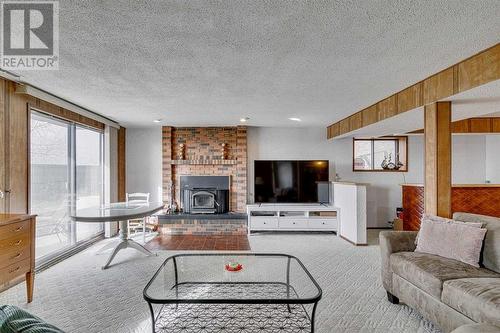 84 Range Way Nw, Calgary, AB - Indoor Photo Showing Living Room With Fireplace