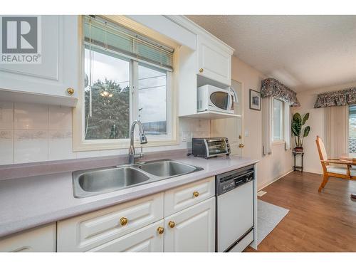 Kitchen overlooking the backyard w/mountain views! - 1251 Ortt Place, Kelowna, BC - Indoor Photo Showing Kitchen With Double Sink