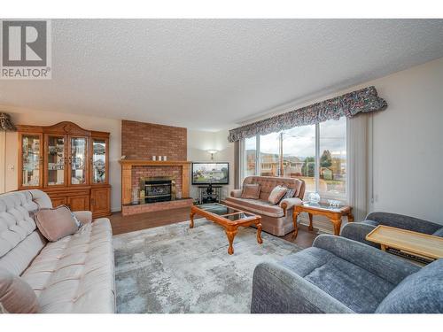 Spacious living room w/newer flooring - 1251 Ortt Place, Kelowna, BC - Indoor Photo Showing Living Room With Fireplace