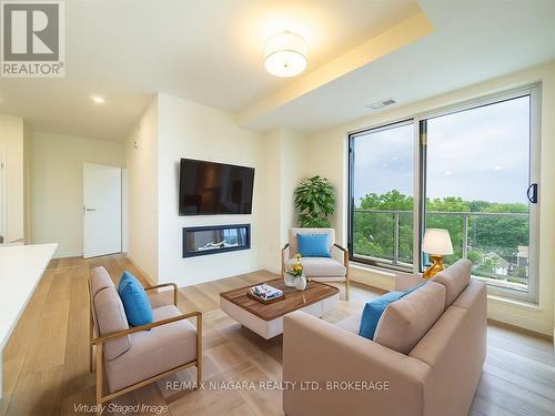 705 - 118 West Street, Port Colborne, ON - Indoor Photo Showing Living Room With Fireplace