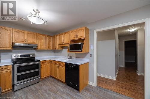 Kitchen featuring sink, dark hardwood / wood-style flooring, double oven range, and black dishwasher - 2555 3Rd 3Rd Avenue Avenue W Unit# 210, Owen Sound, ON - Indoor Photo Showing Kitchen