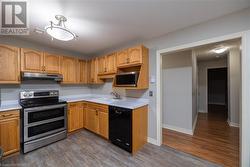 Kitchen featuring sink, dark hardwood / wood-style flooring, double oven range, and black dishwasher - 