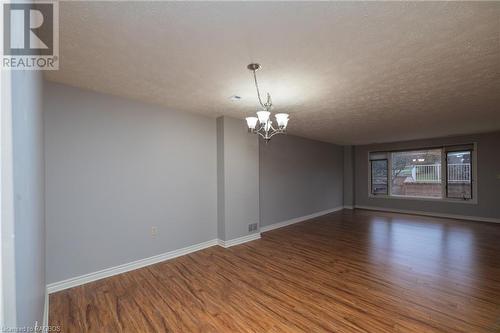 wood-style flooring, a textured ceiling, and an inviting chandelier - 2555 3Rd 3Rd Avenue Avenue W Unit# 210, Owen Sound, ON - Indoor Photo Showing Other Room