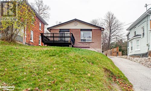 View of front of property featuring a front yard and a deck - 96 Sixth Street, Midland, ON - Outdoor With Deck Patio Veranda