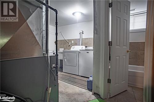 Laundry room featuring washing machine and dryer, heating unit, and light tile patterned floors - 96 Sixth Street, Midland, ON - Indoor Photo Showing Laundry Room