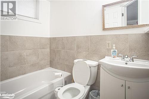 Bathroom featuring a washtub, vanity, tile walls, and toilet - 96 Sixth Street, Midland, ON - Indoor Photo Showing Bathroom