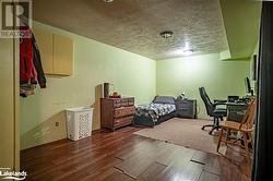 Bedroom with a textured ceiling and dark wood-type flooring - 