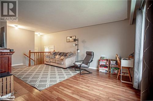 Living room featuring wood-type flooring and a textured ceiling - 96 Sixth Street, Midland, ON - Indoor