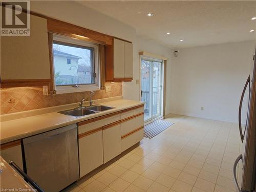 Kitchen with decorative backsplash, a wealth of natural light, sink, and stainless steel dishwasher - 551 Hallmark Drive, Waterloo, ON - Indoor Photo Showing Kitchen With Double Sink