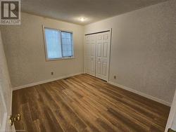 Unfurnished bedroom featuring a closet, dark wood-type flooring, and a textured ceiling - 