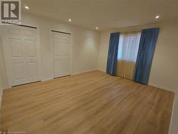 Unfurnished bedroom featuring light hardwood / wood-style floors and multiple closets - 