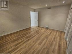 Empty room with dark hardwood / wood-style flooring - 