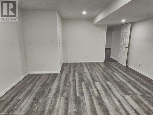 Spare room featuring a textured ceiling and dark hardwood / wood-style flooring - 551 Hallmark Drive, Waterloo, ON - Indoor Photo Showing Other Room