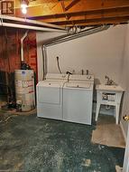 Washroom featuring washing machine and dryer and gas water heater - 