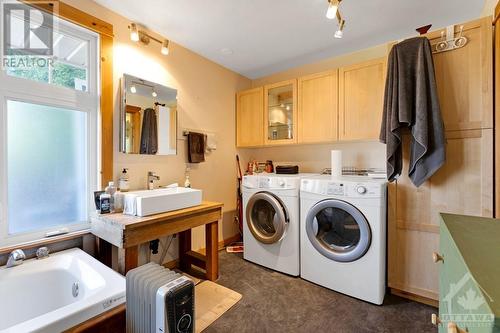 Home's back rental unit main floor 4-pc bathroom with laundry station - 21 Craig Street, Perth, ON 