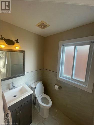 Bathroom featuring tile patterned flooring, vanity, toilet, and tile walls - 126 Peach Blossom Crescent, Kitchener, ON - Indoor Photo Showing Bathroom